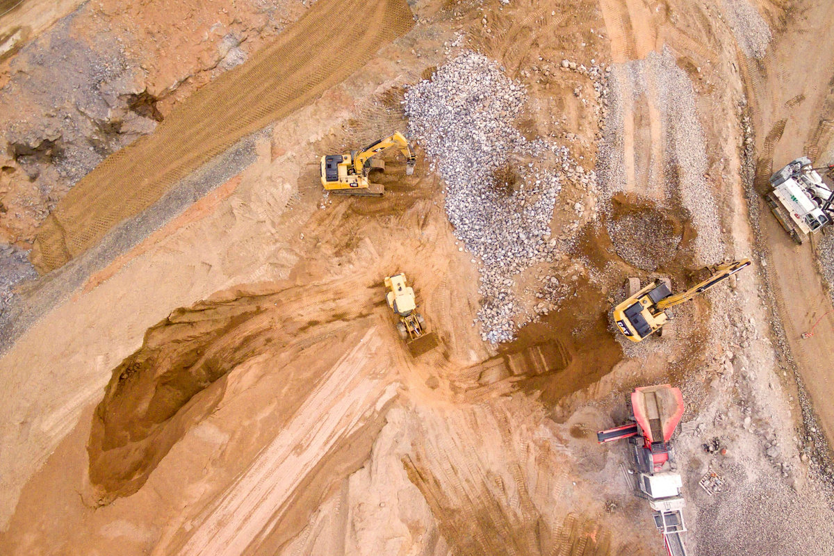 Aerial drone view of an active construction site lit up at night.