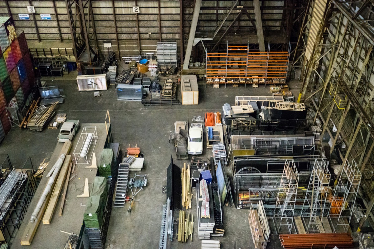 The interior of a large distribution warehouse with racked materials and equipment.