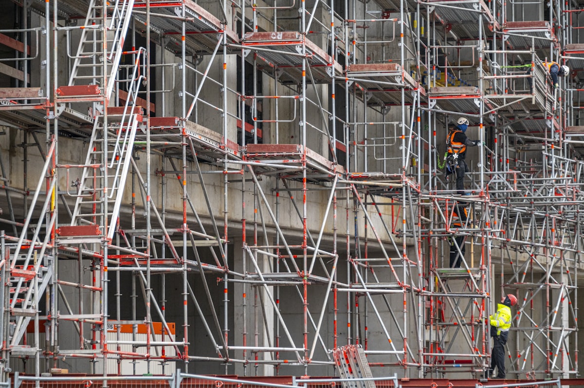 Crews in hi-vis working across dense multi-level scaffolding, the kind of progress and risk Quoto Report reads automatically.